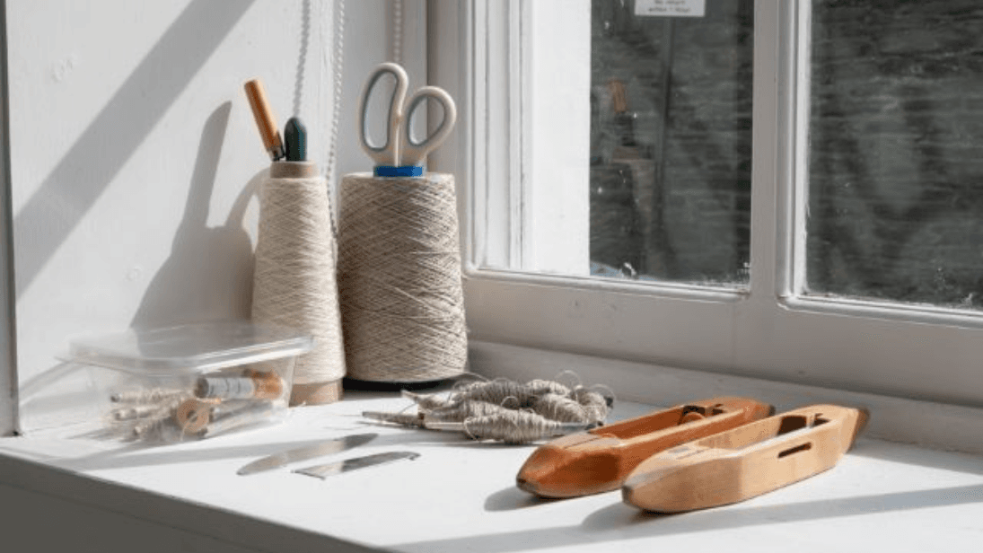 Scissors, thread and sewing materials on a windowsill